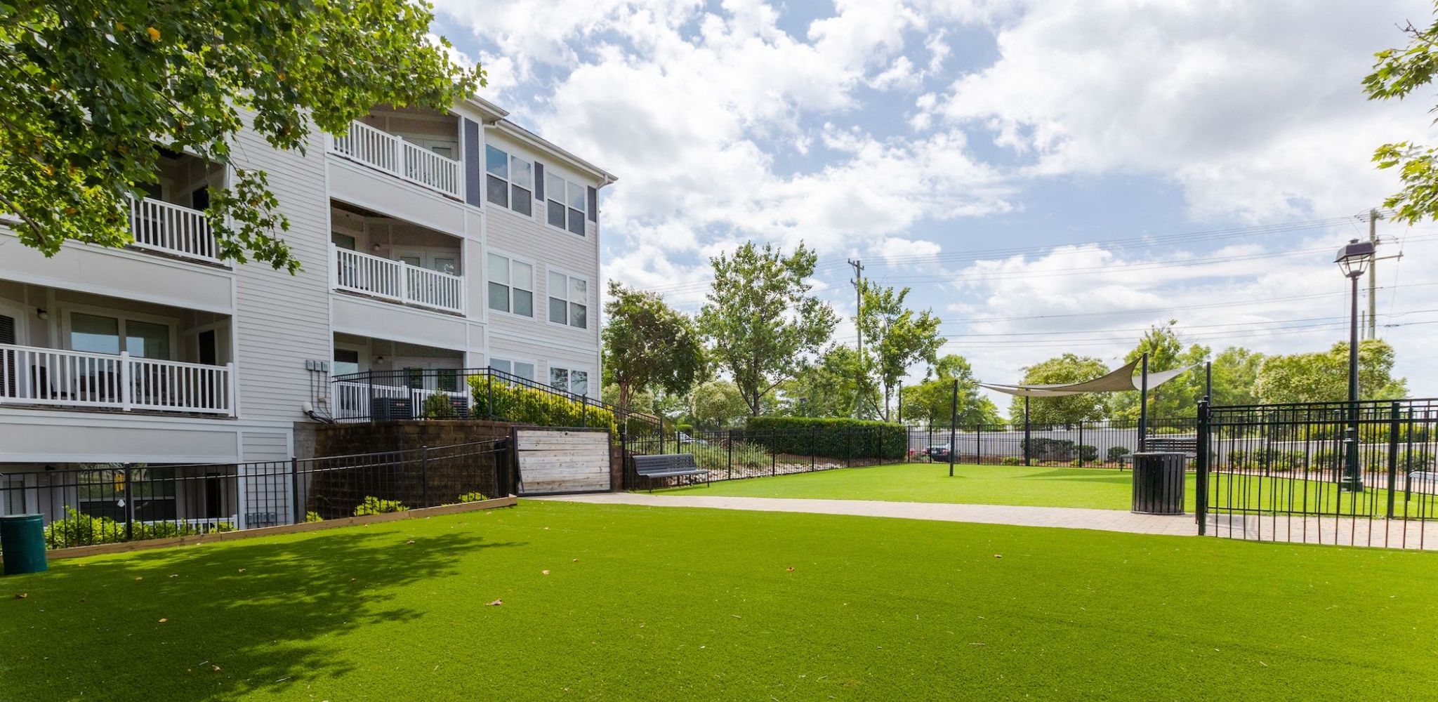 Hawthorne Davis Park apartments community exterior with fenced-in large green lawn
